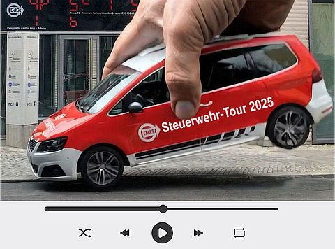 Rotes BdSt-Auto mit Aufschrift ‚Steuerwehr-Tour 2025‘ wird von übergroßer Hand vor Schuldenuhr in die Luft gehoben
