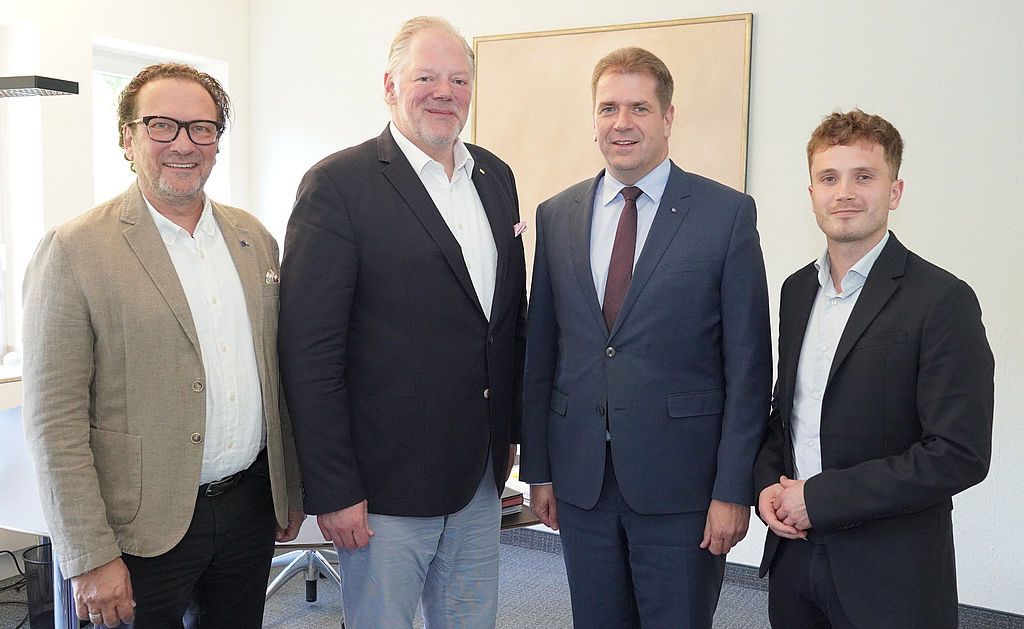 (v.l.): Kurt Wehner (Landesgeschäftsführer, DEHOGA NRW), Patrick Rothkopf (Präsident, DEHOGA NRW), Rik Steinheuer (Vorsitzender, Bund der Steuerzahler NRW), Joscha Slowik (Referent Kommunalfinanzen, Bund der Steuerzahler NRW). "Vier Männer in Businesskleidung stehen nebeneinander in einem Büro; im Hintergrund ein abstraktes Bild an der Wand."