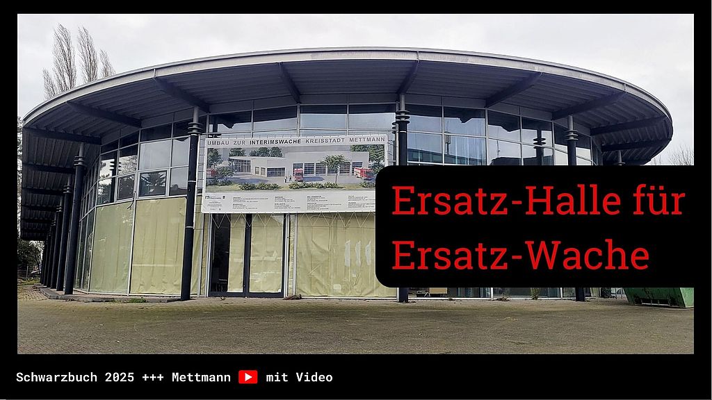 Rundbau mit Glasfassade in Mettmann, Banner zum Umbau als Interim-Feuerwache angebracht