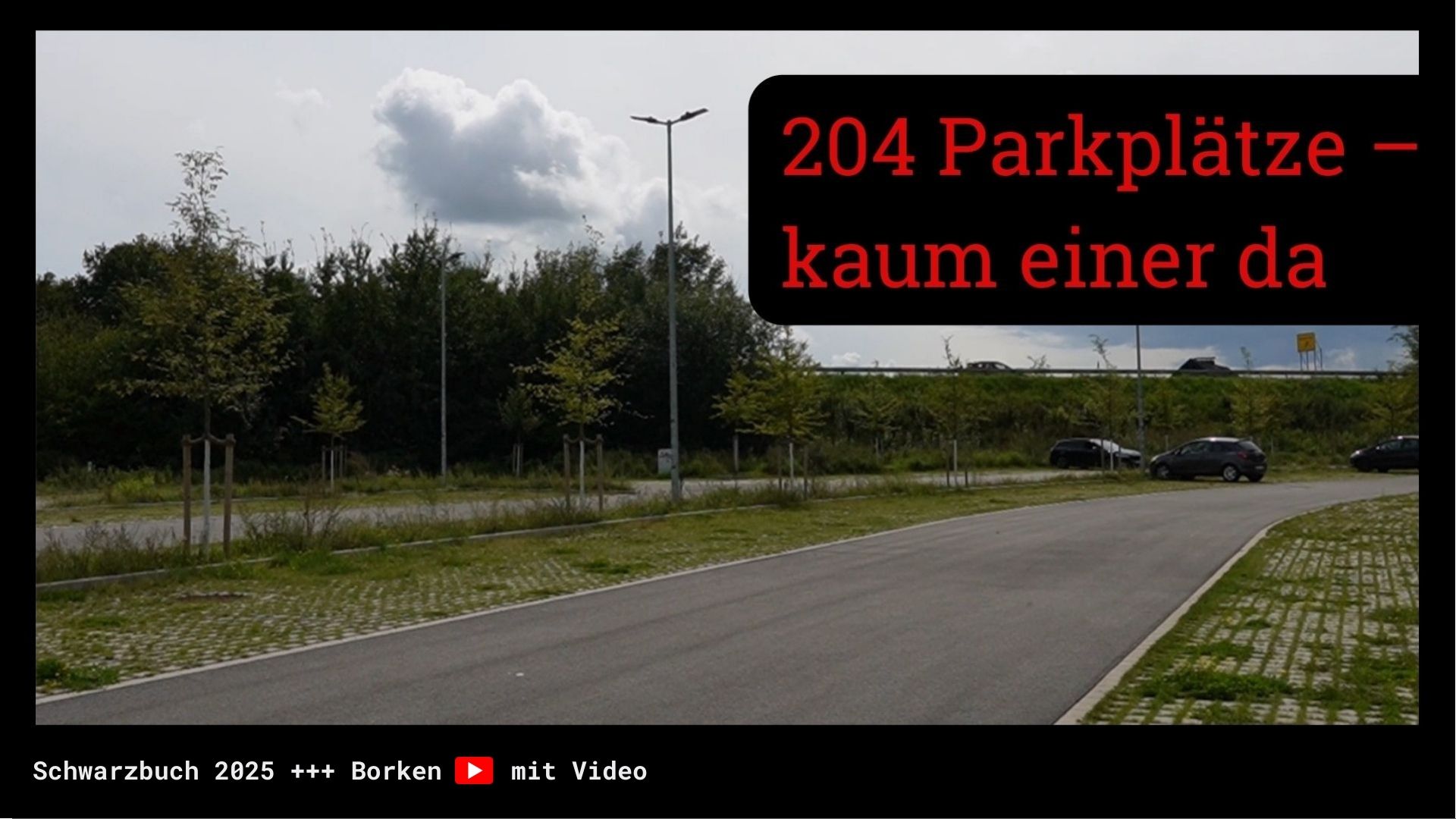 Von Büschen umrandete große Parkplatzfläche mit verpengt parkenden sehr wenigen Autos.