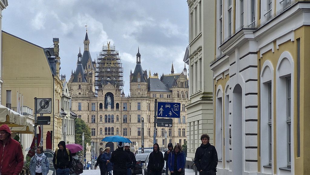 Schweriner Schloss mit Gerüst an der Goldenen Kuppel  und Touristen davor