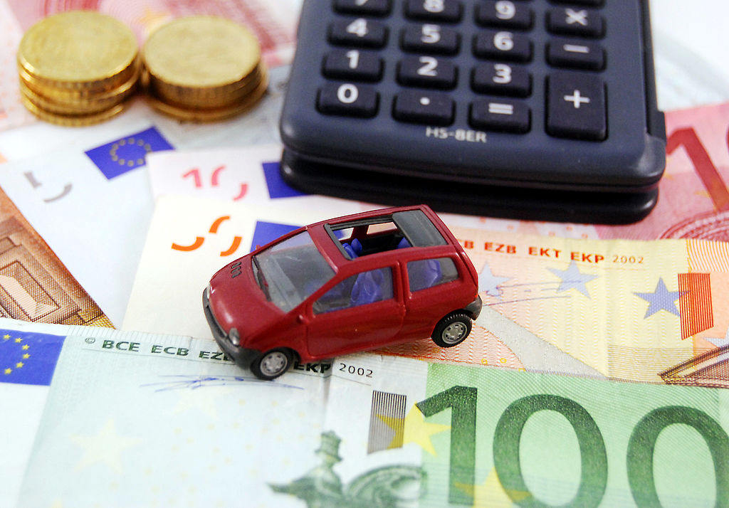 Spielzeugauto und Taschenrechner auf Geldscheinen